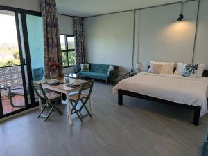 a bedroom with a bed and a table and a couch at Loei Valley Farm Stay in Wang Saphung +24 photos