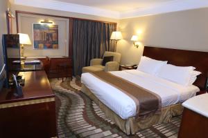a hotel room with a large bed and a chair at Jianguo Hotel in Beijing +42 photos