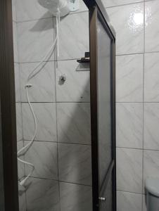 a shower with a glass door in a bathroom at Rua da Expo Itaguaí in Itaguaí