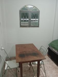 a room with a table and chairs and a bird cage at Rua da Expo Itaguaí in Itaguaí