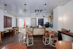 a restaurant with tables and chairs and a counter at RedDoorz Near MRT Bendungan Hilir in Jakarta