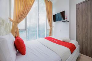 a bedroom with a bed with a large window at RedDoorz Near MRT Bendungan Hilir in Jakarta