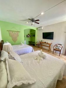 a bedroom with two beds and a flat screen tv at Pelican Inn at Las Dunas Chelem in Chelem