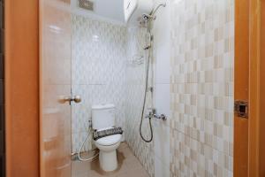 a small bathroom with a toilet and a shower at RedDoorz Near MRT Bendungan Hilir in Jakarta +20 photos