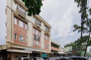 a building with cars parked in front of it at Sans Vibes Hotel Malabar in Bandung