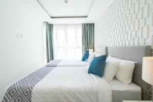 a bedroom with a large white bed with blue pillows at Seavale patong phuket in Patong Beach