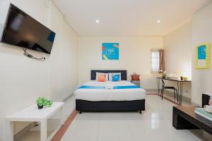 a bedroom with a bed and a flat screen tv at Sans Vibes Hotel Malabar in Bandung