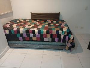 a bed in a room with a colorful blanket on it at Comfortable suite-style studio apartment to rest in Flandes +1 photo