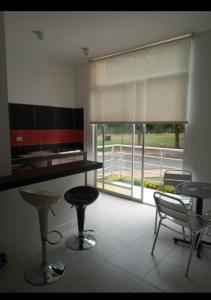 a kitchen with two tables and chairs and a large window at Comfortable suite-style studio apartment to rest in Flandes