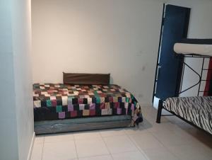 a bedroom with a bed with a colorful blanket at Comfortable suite-style studio apartment to rest in Flandes