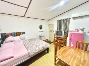 a bedroom with a bed and a table and a tv at D&Dโฮม@เขาค้อ in Khao Kho
