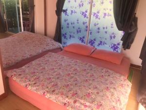 two beds in a room with flowers on the wall at D&Dโฮม@เขาค้อ in Khao Kho