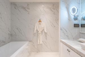 a white robe hanging on a wall in a bathroom at Seavale patong phuket in Patong Beach