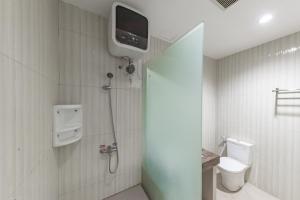 a bathroom with a toilet and a tv on the wall at Sans Vibes Hotel Malabar in Bandung +37 photos