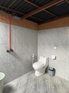 a bathroom with a white toilet in a room at Sun Grace Villa and Camp in Sembalun Lawang