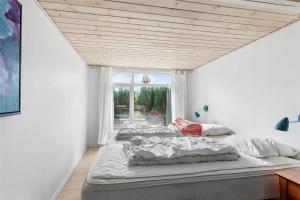 two beds in a room with a window at FY273-Millinge-Buursminde-2 in Millinge