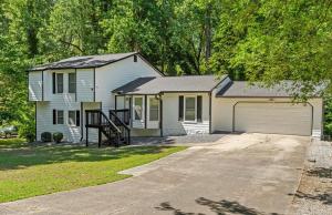 a white house with a garage and a driveway at Relaxation spot lawrenceville in Lawrenceville