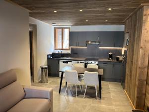 a kitchen with a table and chairs in a room at Mont Joly 2 in Le Baplieu
