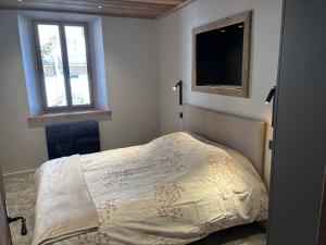 a bedroom with a bed and a television on the wall at Mont Joly 2 in Le Baplieu