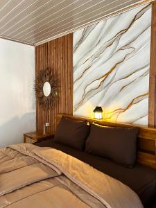 a bedroom with a bed with a large painting on the wall at Sun Grace Villa and Camp in Sembalun Lawang