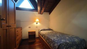 a bedroom with a bed and a dresser and a window at Le Perce Neige in Morgex