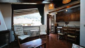 a kitchen with a table and chairs and a window at Le Perce Neige in Morgex