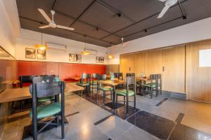 a restaurant with wooden walls and tables and chairs at Treebo Premium Corner Stay in Coimbatore