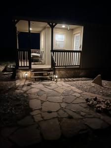 a porch of a house at night with a bench at Grand Canyon tiny homes in Williams
