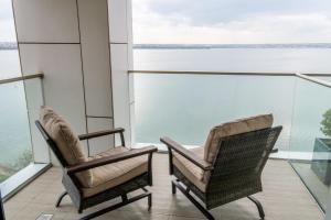two chairs on a balcony with a view of the water at Hotel Victor in Mamaia