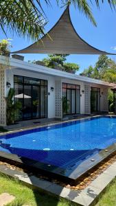 a swimming pool in front of a house at Private Bungalow, Large Salt Water Pool & Jacuzzi, Super Fast WIFI 100Mbps in Phumĭ Kruŏs