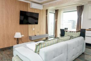 a living room with a white couch and a television at Hotel Victor in Mamaia