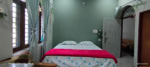 a bedroom with a bed with a pink blanket at Rawat Homestay in Rishīkesh