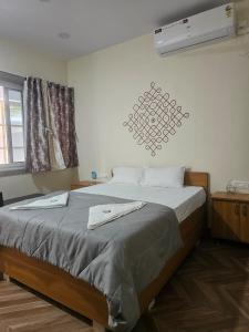 a bedroom with a bed with a fan on the wall at Hampi Rock-Inn in Hampi