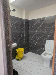 a bathroom with a white toilet and a sink at Hampi Rock-Inn in Hampi