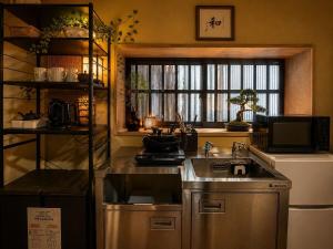 a kitchen with a sink and a stove and a window at 結莉の宿 高槻 in Takatsuki