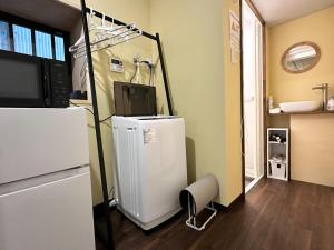 a kitchen with a refrigerator and a chair in a room at 結莉の宿 高槻 in Takatsuki