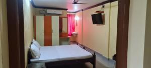 a small room with a bed and a mirror at LEMON RESIDENCY By Chungath in Trichūr