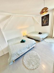 two beds in a room with rugs on the floor at l'Echappée belle Le Duplex 10 min "Europa Park" in Rhinau