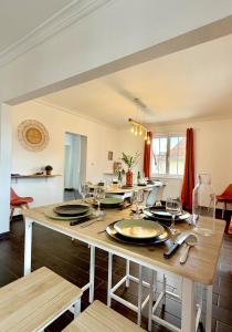 a dining room with a table with wine glasses at l'Echappée belle Le Duplex 10 min "Europa Park" in Rhinau