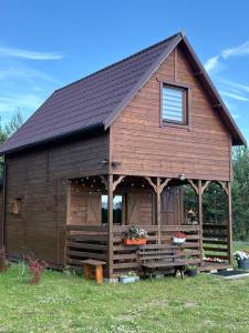 a large wooden cabin with a gambrel roof at Orla polana in Gorczyca
