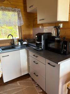 a kitchen with white cabinets and a black counter top at Orla polana in Gorczyca