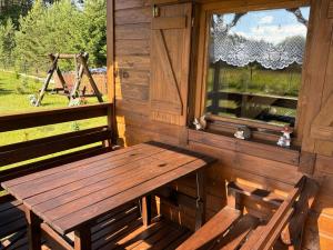 a wooden bench sitting on the porch of a cabin at Orla polana in Gorczyca +1 photo