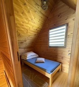 a small room with a bed in a wooden cabin at Orla polana in Gorczyca