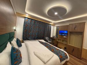 a bedroom with a bed and a tv in it at The Cedar Pahalgam in Pahalgām