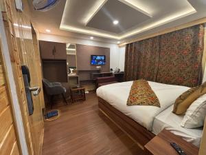 a hotel room with a bed and a television at The Cedar Pahalgam in Pahalgām