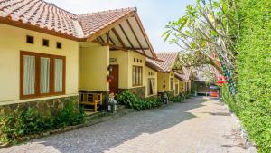 a cobblestone street in front of a house at Cemara Asri Guesthouse in Lembang