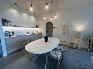 a kitchen with a white table and chairs in a room at Villa Rive in Ostend