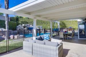 a covered patio with a couch and a table at Beautiful Backyard Oasis 5 bedroom 3 Bathroom Home in Placentia