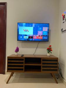 a flat screen tv on a wall with two plants at Hotel Melodyinn in Gujrāt