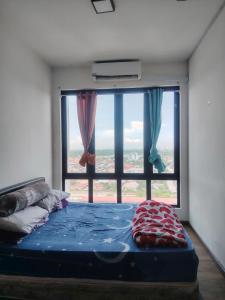 a bed in a room with a large window at Suria jaya studio condo shah alam in Shah Alam